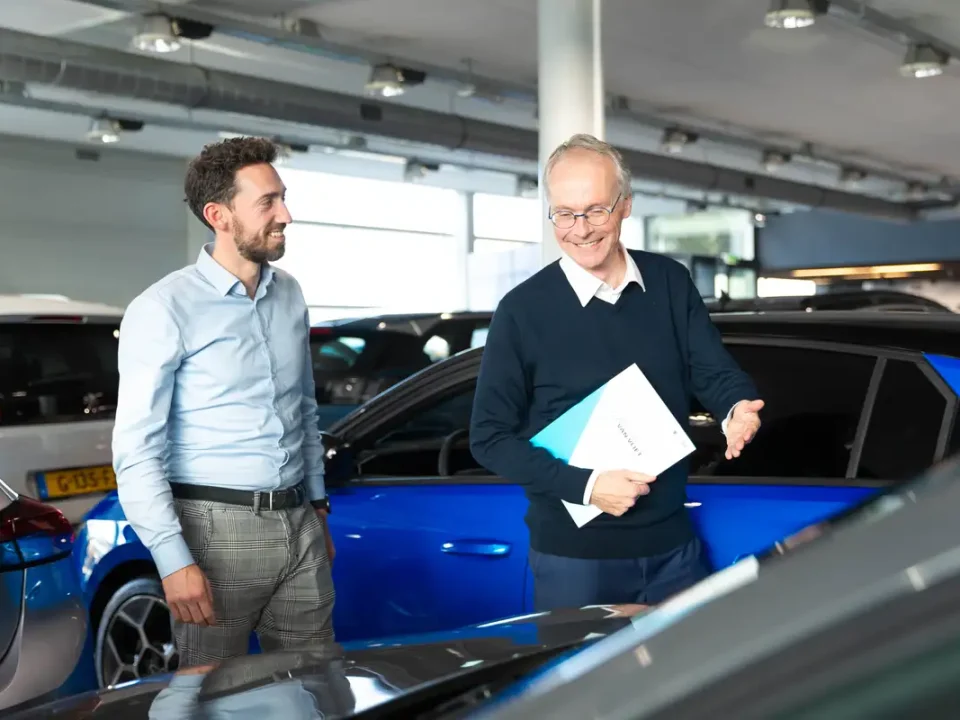 Verkoper en klant in de showroom van Autocentrum Van Vliet