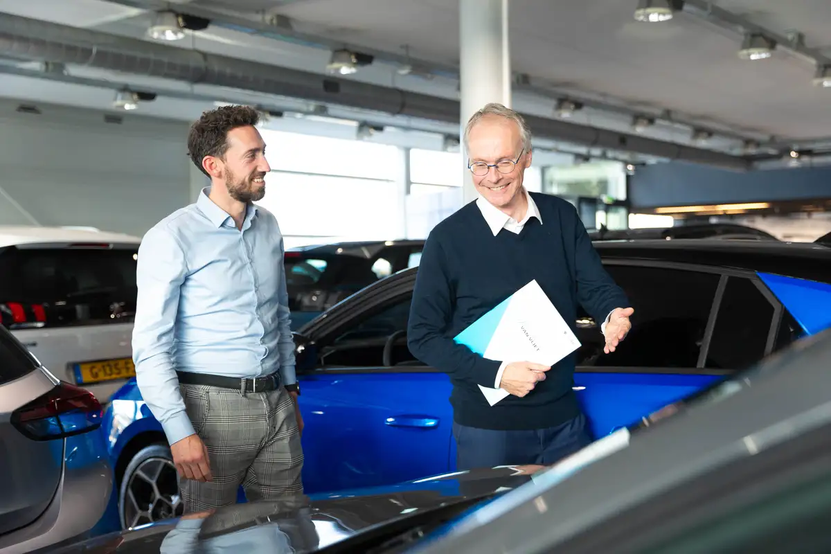 Verkoper en klant in de showroom van Autocentrum Van Vliet