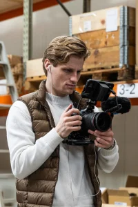 Videograaf van Upbrand Agency met camera in een magazijn