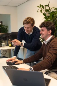 Sem en Mees van Upbrand Agency overleggen lachend achter de computer